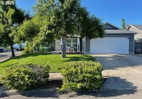6004 Quartz Ave, Springfield, OR 97478 - obstructed view of property featuring a garage, driveway, and a front lawn