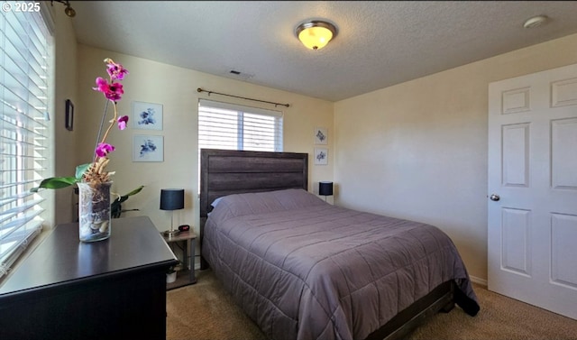 carpeted bedroom featuring a textured ceiling