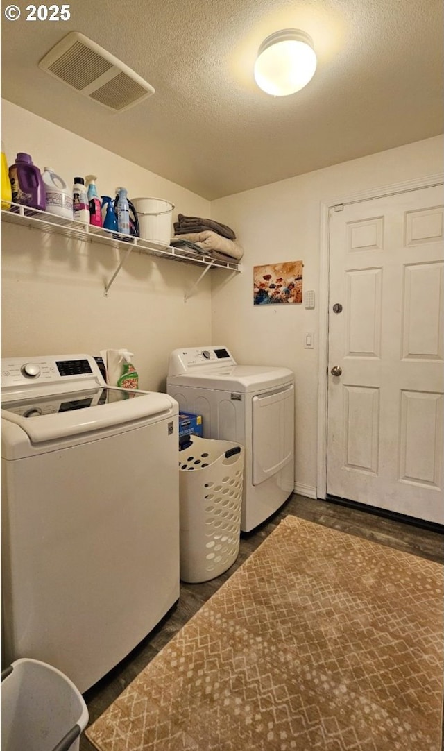 laundry area with washer and dryer and a textured ceiling