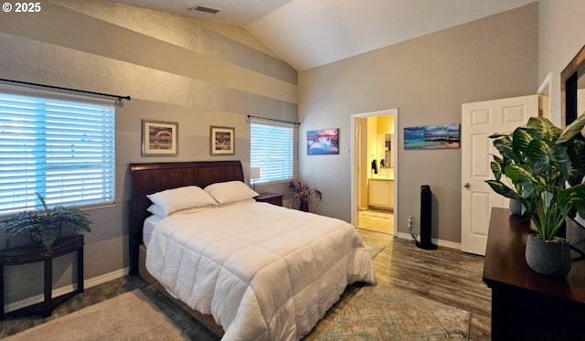 bedroom featuring hardwood / wood-style flooring, lofted ceiling, ensuite bathroom, and multiple windows