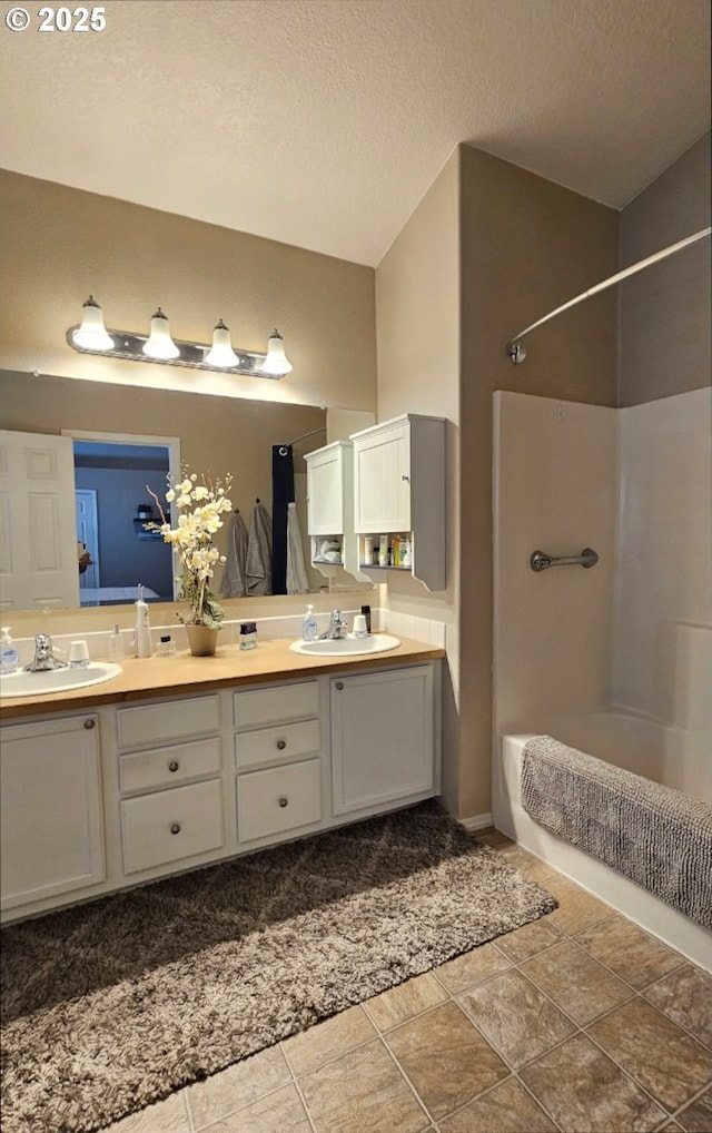 bathroom with vanity, shower / washtub combination, and a textured ceiling