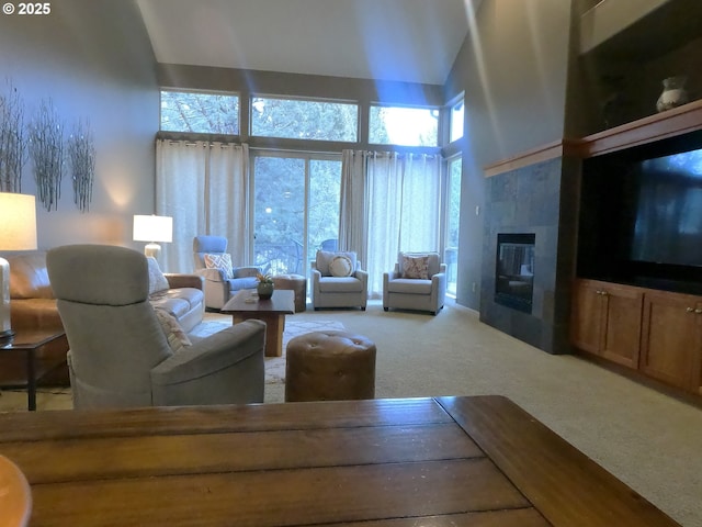 carpeted living room featuring a towering ceiling and a tile fireplace