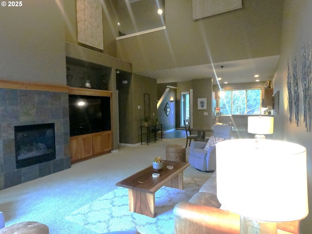 living room featuring light colored carpet, a tile fireplace, and a high ceiling