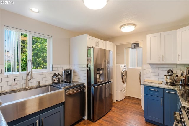 20657 SW Nantucket Ln, Beaverton, OR 97006 - kitchen with stainless steel appliances, a sink, washer and clothes dryer, blue cabinets, and white cabinetry