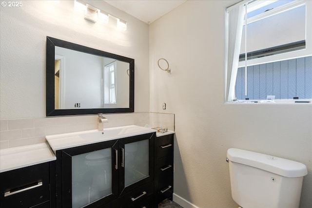 20657 SW Nantucket Ln, Beaverton, OR 97006 - bathroom featuring toilet, vanity, decorative backsplash, and baseboards