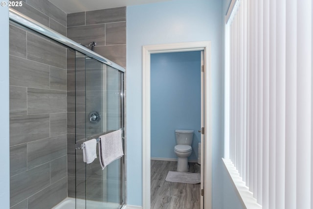 120 Sundance Ct, Roseburg, OR 97471 - bathroom with a stall shower, toilet, wood finished floors, and baseboards