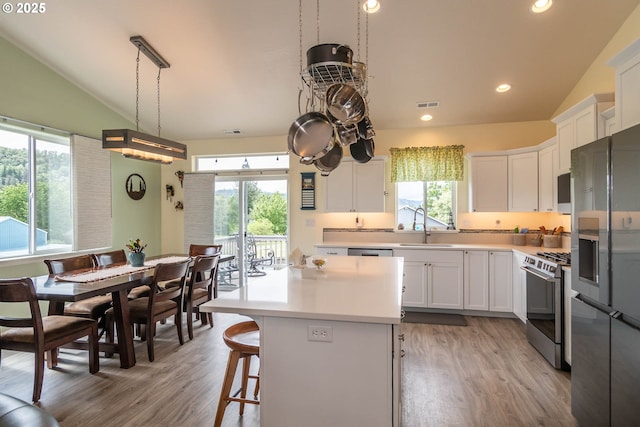 120 Sundance Ct, Roseburg, OR 97471 - kitchen featuring stainless steel appliances, vaulted ceiling, a sink, plenty of natural light, and light wood-style flooring