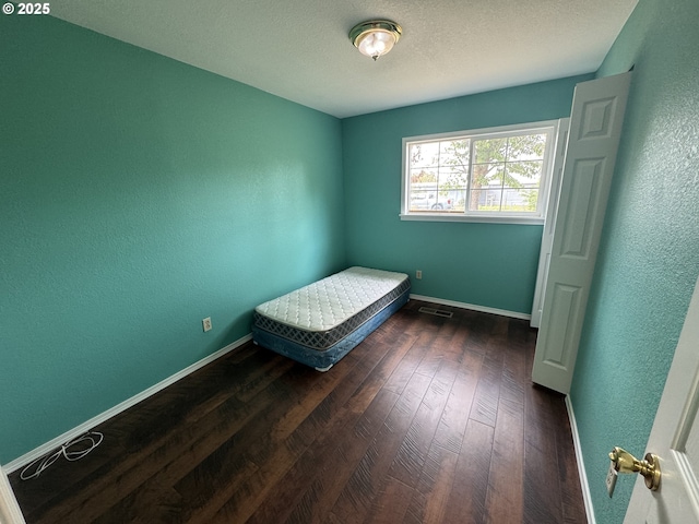 600 NE Oregon Ave, Irrigon, OR 97844 - bedroom featuring dark wood finished floors, baseboards, a textured wall, and a textured ceiling
