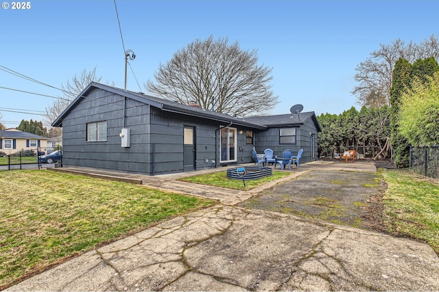 back of property with a patio, a lawn, a chimney, and fence