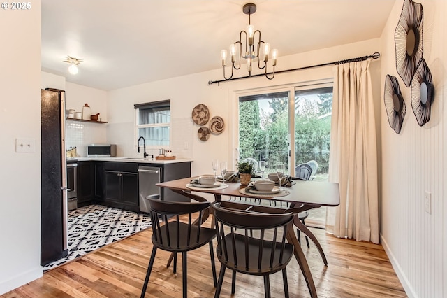 dining room featuring a chandelier, baseboards, and light wood-style floors