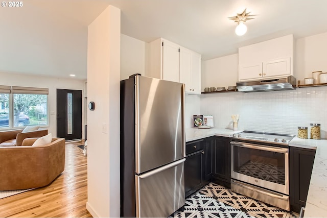 kitchen featuring under cabinet range hood, white cabinetry, stainless steel appliances, and light countertops