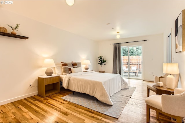 bedroom with access to outside, baseboards, and light wood finished floors