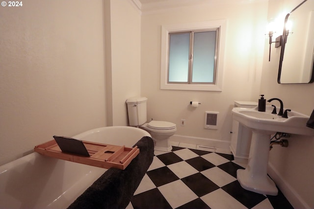 full bathroom featuring a freestanding tub, toilet, baseboards, and tile patterned floors