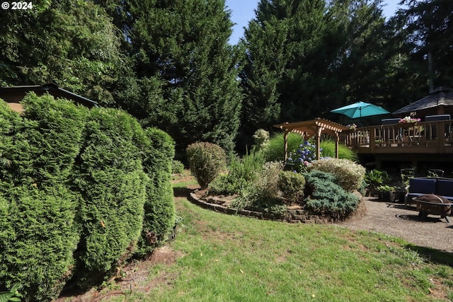 view of yard with an outdoor fire pit, a wooden deck, and a pergola