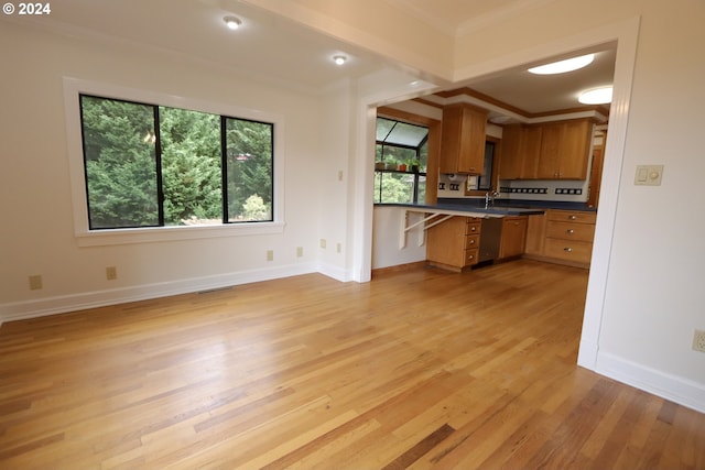 kitchen with baseboards, ornamental molding, brown cabinets, open floor plan, and light wood-type flooring