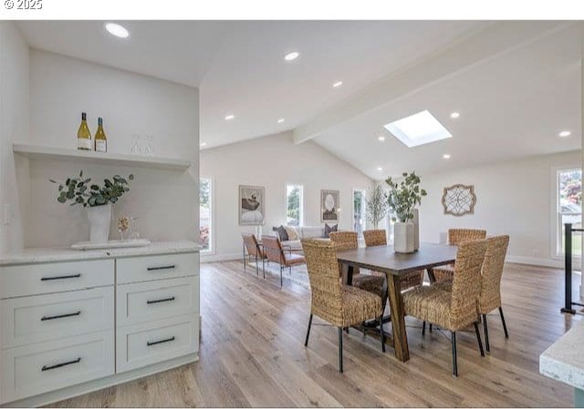 dining space featuring lofted ceiling with skylight, recessed lighting, light wood-style flooring, and baseboards