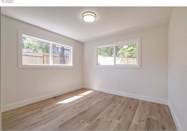 unfurnished room with baseboards and wood finished floors