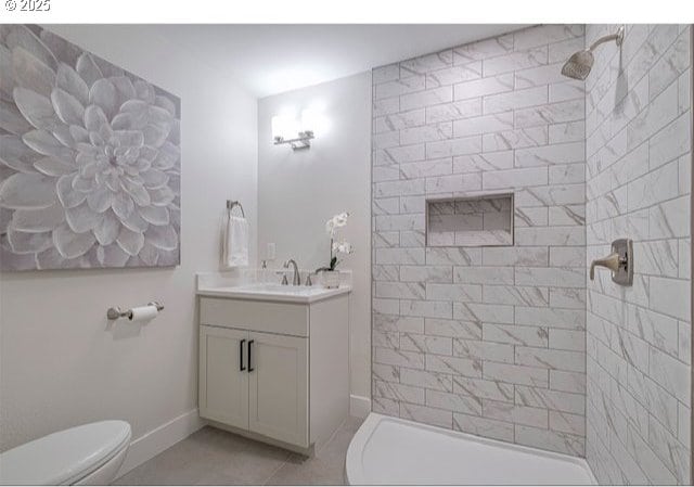 full bathroom featuring tile patterned floors, toilet, a tile shower, baseboards, and vanity