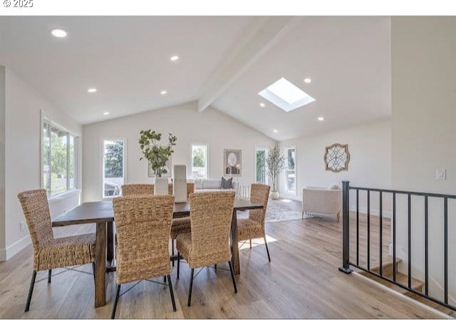 dining room featuring vaulted ceiling with skylight, recessed lighting, light wood-style floors, and a wealth of natural light