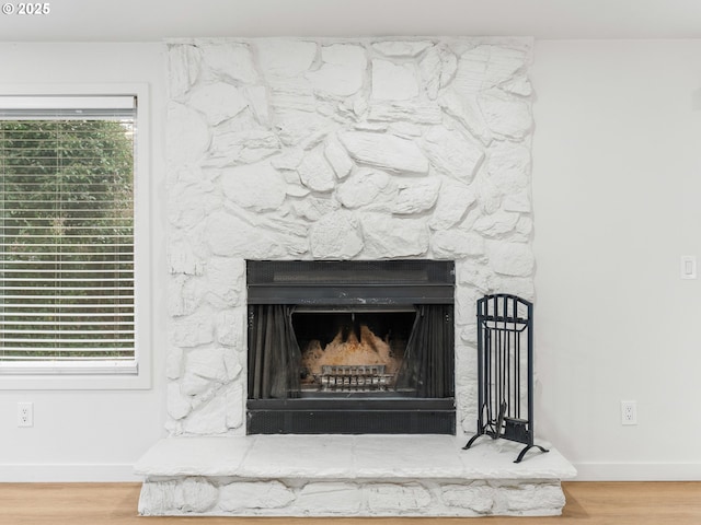 details featuring a stone fireplace and hardwood / wood-style flooring