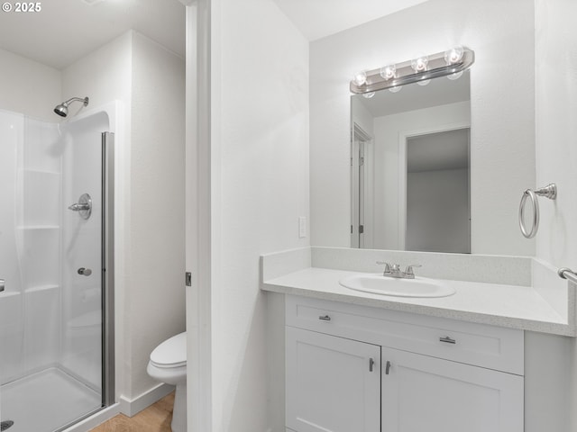 bathroom featuring toilet, wood-type flooring, walk in shower, and vanity