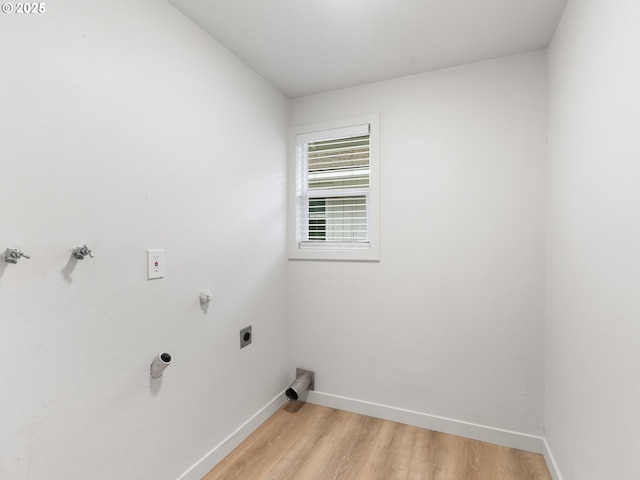 clothes washing area featuring light wood-type flooring, hookup for a gas dryer, and hookup for an electric dryer