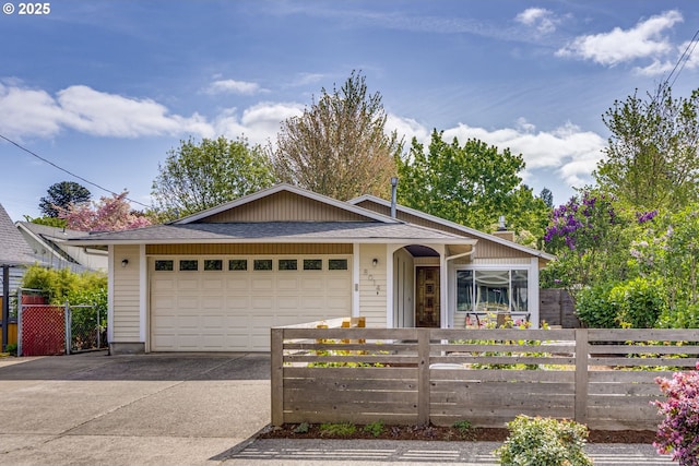 ranch-style home featuring concrete driveway, an attached garage, and a fenced front yard