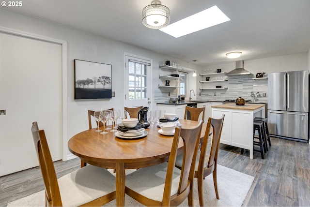 dining space with a skylight and wood finished floors