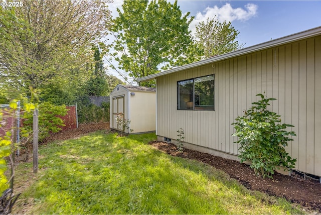 view of yard featuring a shed, an outbuilding, and fence