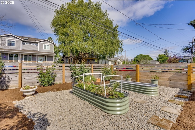 view of yard featuring fence and a vegetable garden