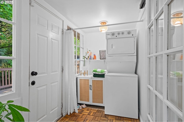 laundry room with stacked washer / drying machine and cabinet space