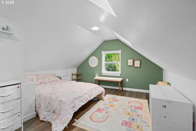 bedroom featuring baseboards, wood finished floors, and vaulted ceiling