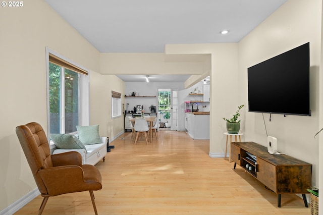 living area with light wood-style floors, baseboards, and recessed lighting