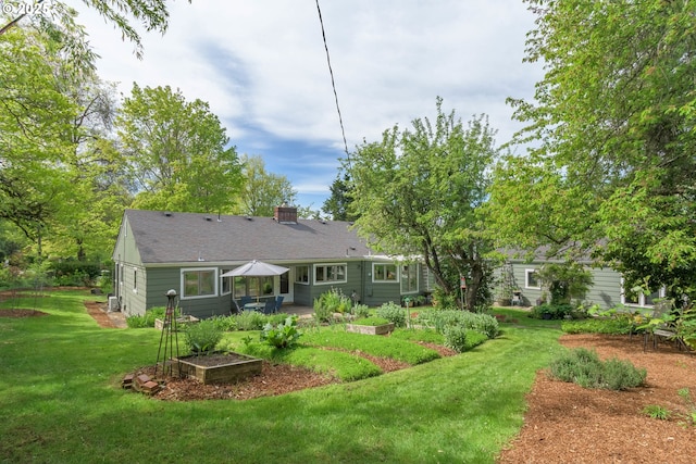 back of property with a lawn, a patio, and a chimney