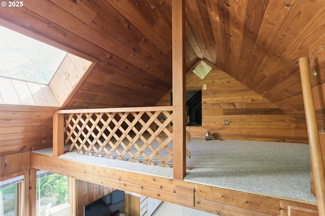 interior space featuring wooden walls, wood ceiling, and lofted ceiling with skylight