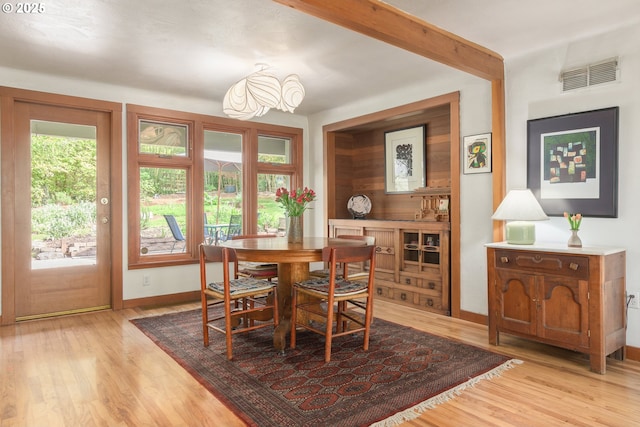 dining space with baseboards, visible vents, and light wood-style floors