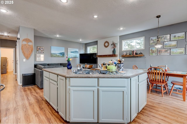 kitchen with white cabinetry, a center island, and decorative light fixtures