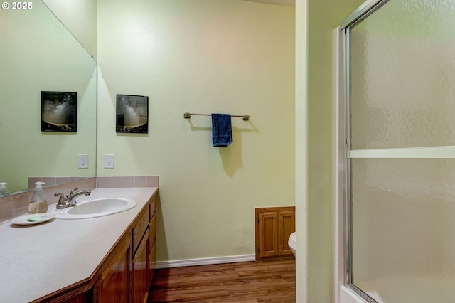 bathroom with vanity, hardwood / wood-style floors, an enclosed shower, and toilet