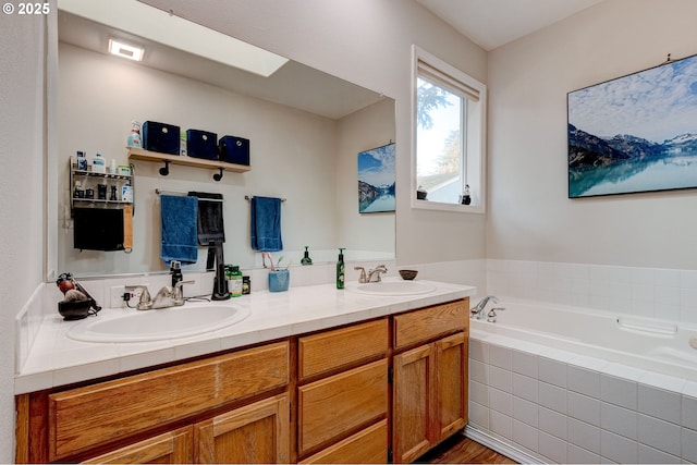 bathroom featuring a relaxing tiled tub and vanity