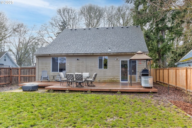 back of property with a wooden deck, a gazebo, and a lawn