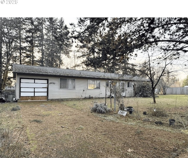 view of front of house featuring driveway, an attached garage, fence, and a front yard