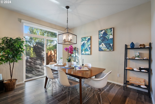 dining area with dark wood-type flooring and a chandelier