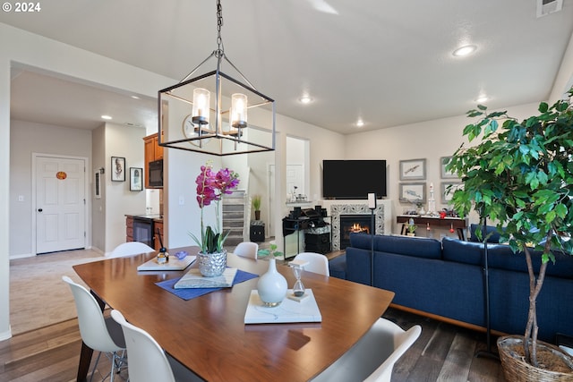 dining area with wood-type flooring and an inviting chandelier