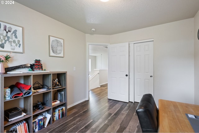 home office with dark wood-type flooring and a textured ceiling