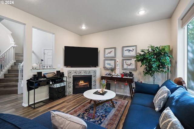 living room featuring a tiled fireplace and hardwood / wood-style floors