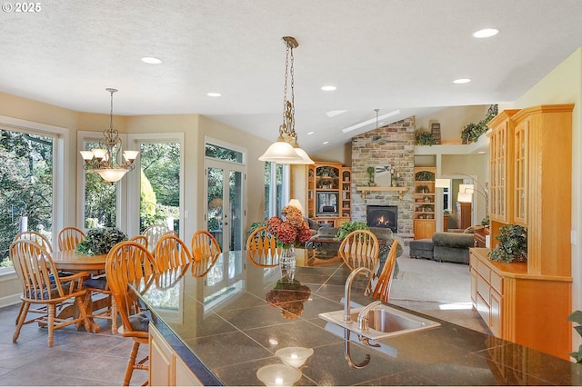 5632 Mac Way, Silverton, OR 97381 - dining room featuring a stone fireplace, recessed lighting, a chandelier, vaulted ceiling, and a textured ceiling