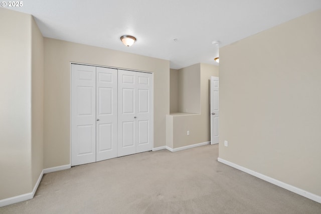 unfurnished bedroom featuring a closet, baseboards, and carpet flooring