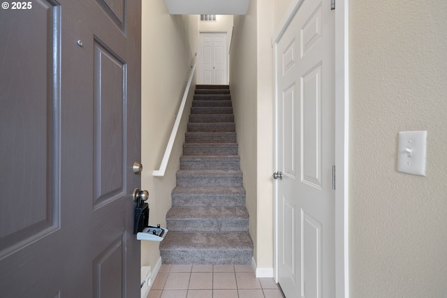 staircase with tile patterned floors and visible vents