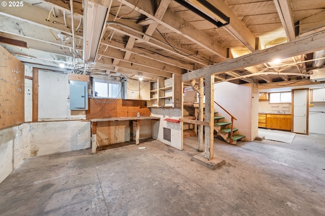 basement with electric panel and a wealth of natural light