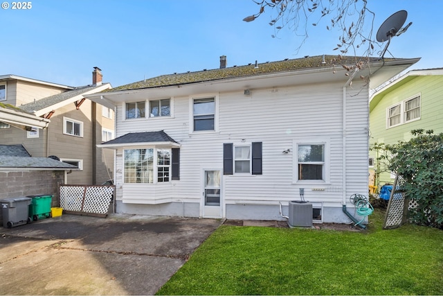 rear view of property with cooling unit, a yard, and a patio